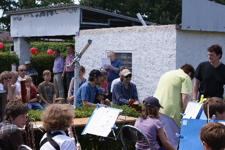 bunte Menschenmasse teilweise mit Musikinstrumenten